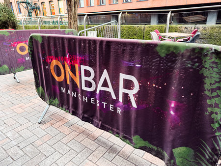 Manchester, UK - January 22, 2026: Bright barricade banner for On Bar in Manchester, featuring purple graphics and urban street settingのeditorial素材