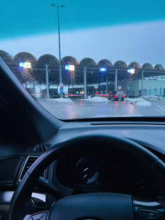 View from the driver seat at a ukrainian polish border plaza in winter, blue tinted scene.の写真素材