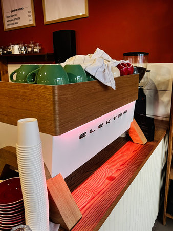 Lviv, Ukraine - February 07, 2026: A stylish cafe scene featuring an Elektra espresso machine, green mugs, and tidy counter setup.のeditorial素材