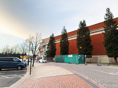 Manchester, UK - January 23, 2026: A quiet city street in Manchester with Trafford Centre construction fencing, parked vehicles, and tall evergreen trees.のeditorial素材