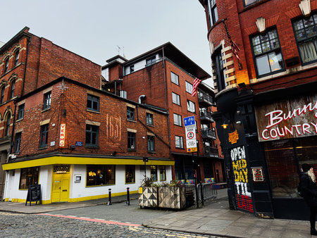 Manchester, UK - January 26, 2026: Vibrant Manchester street corner with red brick architecture, a bright yellow shopfront, and urban atmosphere.のeditorial素材