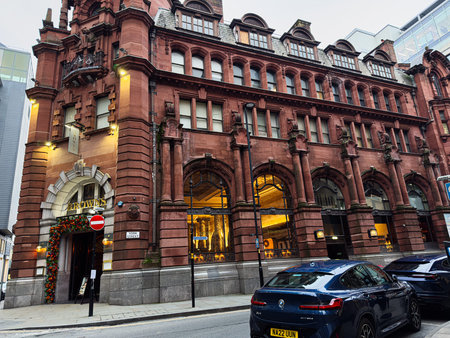 Manchester, UK - January 29, 2026: Historic red brick building in Manchester houses Browns, arched windows glow with warm shop lighting on a city York street.のeditorial素材