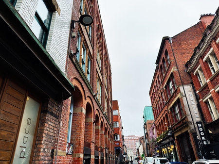 Manchester, UK - January 30, 2026: A lively Manchester street lined with red brick architecture,...