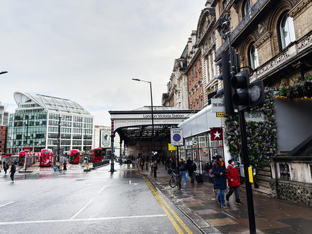London, UK - February 01, 2026: Bustling street near Victoria Station with pedestrians, commuters, and ornate architecture on a rainy day.のeditorial素材