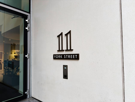Modern exterior wall with address 11 and York Street signage in Manchester city.