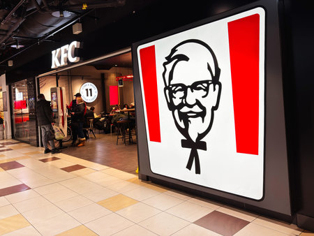 Edinburgh, Scotland, UK - February 15, 2026: Busy KFC outlet with illuminated Colonel Sanders logo...