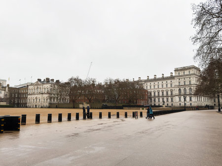 London, UK - February 01, 2026: Cloudy London scene with grand white buildings, trees, and a few walkers on a wet day.のeditorial素材