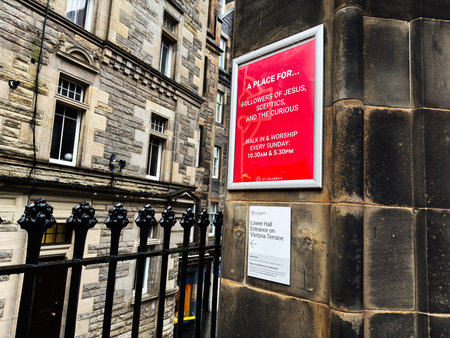 Edinburgh, Scotland, UK - February 15, 2026: Red St Columba's poster mounted on a historic sandstone church facade in Edinburgh directing visitors to St Columbas lower hall.のeditorial素材