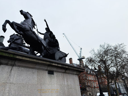 London, UK - February 01, 2026: Bronze chariot Boadicea and Her Daughters sculpture of rearing horses atop a stone pedestal beside London UK urban architecture and cranes.のeditorial素材