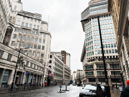 London, UK - February 01, 2026: Empty wet street in London UK framed by office towers, Underground signage and urban concrete architecture.のeditorial素材