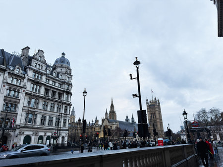 London, UK - February 01, 2026: Crowded London street with the Palace of Westminster towers,...