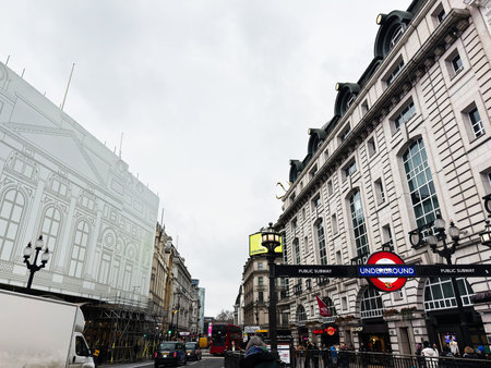 London, UK - February 02, 2026: Crowded London UK street scene with Underground entrance, red buses,...