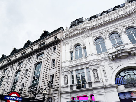 London, UK - February 02, 2026: White ornate city faÃ§ade towers above a London Underground sign, highlighting historic architecture and urban transport.のeditorial素材