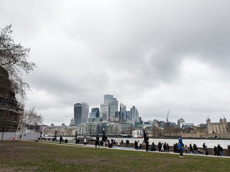 London, UK - February 02, 2026: People gather and walk along the River Thames with the modern London skyline and Tower of London visible.のeditorial素材