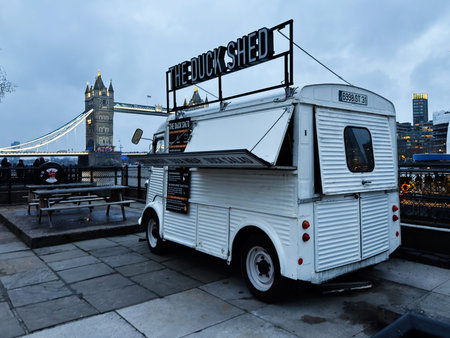 London, UK - February 02, 2026: White vintage food truck serving riverside customers beside Tower...
