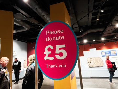 Liverpool, UK - May 16, 2026: Bright pink donation sign asking visitors to donate five pounds inside a Liverpool museum gallery.