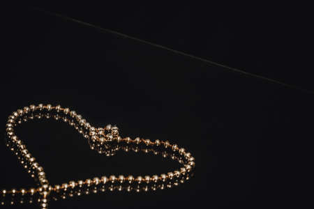 Golden Christmas tree chain motive of a heart. Card decoration. Seasonal background.の写真素材