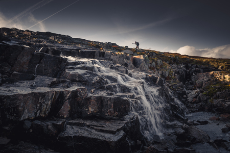 Lonely hiker in Sylan mountains. Flowing mountain stream and waterfall.の写真素材