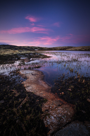 Midnight light in summer time, middle Norway. Light reflections on the surface of small mountain lake.の写真素材