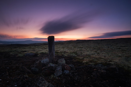 Long exposure on night sky and landscapes in area of Nordgruvefeltet in middle Norway. Wooden pole in the ground.の写真素材