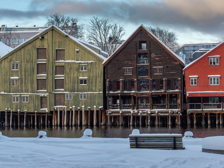 Old wooden buildings, magazines, by the shores of Nidelva river, winter time in Trondheim, Norway.の写真素材