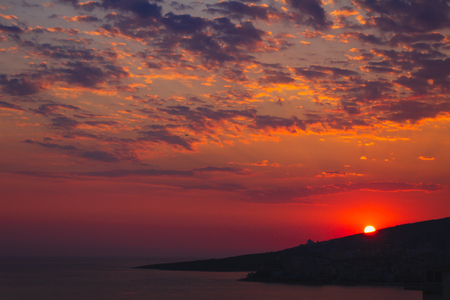 Saranda in Albania. Summer sunset above the city buildings. Beautiful evening sky. calm Adriatic Sea.の写真素材