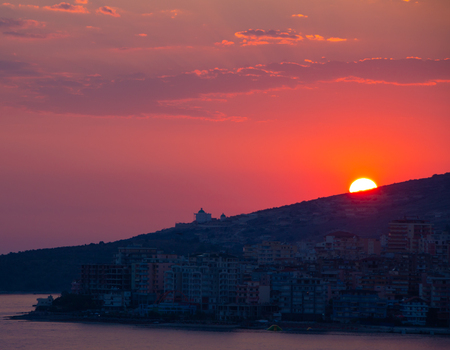 Saranda in Albania. Summer sunset above the city buildings. Beautiful evening sky. calm Adriatic Sea.の写真素材