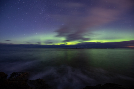North lights Aurora Borealis seen from Atlantic Ocean Road - Atlanterhavsveien in winter night. Norwegian wintertime. Nice starry sky and green lights.の写真素材