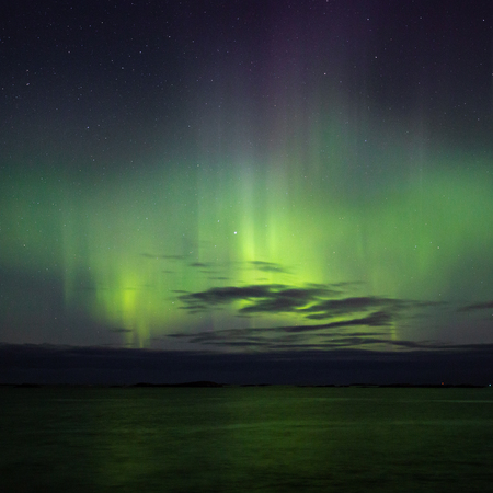 North lights Aurora Borealis seen from Atlantic Ocean Road - Atlanterhavsveien in winter night. Norwegian wintertime. Nice starry sky and green lights.の写真素材
