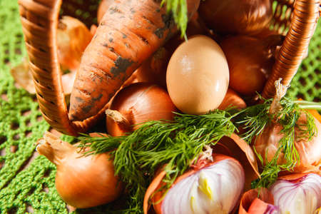 Fresh vegetables and herbs near basketの写真素材