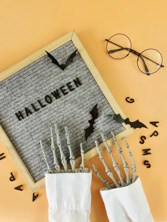 the skeletons hands lay out the word Halloween in a wooden frameの写真素材