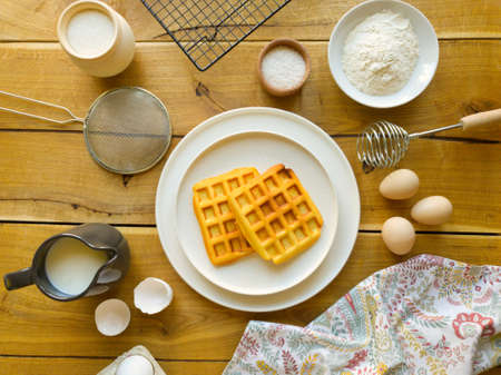 Freshly prepared waffles on a wooden tableの写真素材