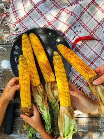 fresh grilled corn in children's hands