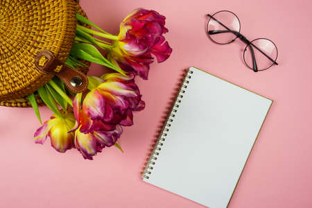 a notebook for notes and pink tulips in a wicker bagの写真素材