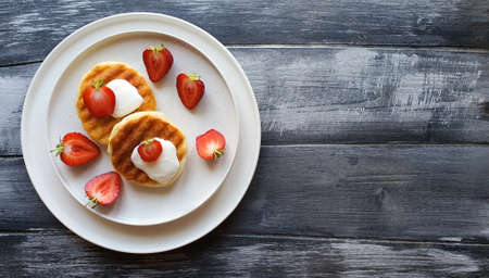Freshly made pancakes with strawberries are in a white plateの写真素材