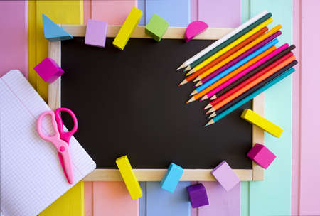 Bright stationery is laid out at the blackboardの写真素材
