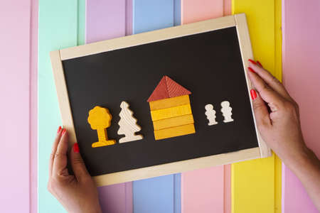 Womens hands lay out figures made of cubes on the boardの写真素材