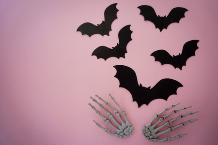 Skeleton scares away bats on pink backgroundの写真素材