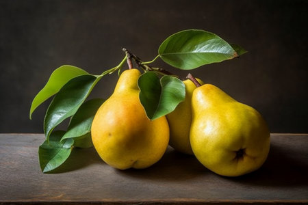 Ripe yellow pears with green leaves on a dark background.の素材
