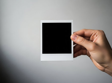 Hand holding blank polaroidの素材