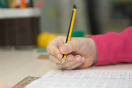 Book is on the table, the boy is doing homework