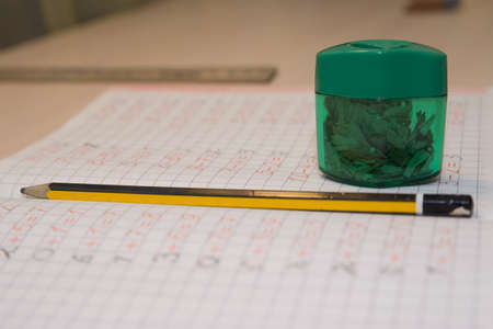 Pencil Sharpener, pencil and notebook are on the tableの写真素材