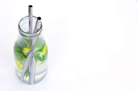 Refreshing Drink, Water With Lemon, Ginger, Mint On A White Background with metal cocktail straw. steel cocktail eco tube for reusable and reduce the use of plastic straw. Zero waste. Space for textの写真素材