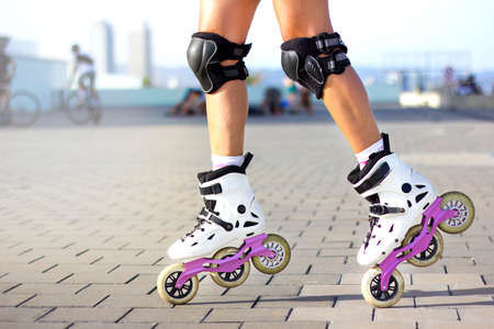 Close-up of woman's legs with inline skates doing roller skating tricks outside. Summertime sport...