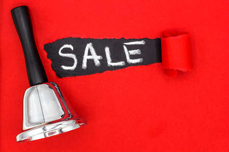 Black bell and ward SALE on torn red paper. The discount season is open. Time for a sale. Space for textの写真素材