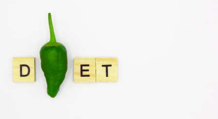 Diet plan concept. Word DIET made with a green paper and wooden letters on white background with space for text. Vegetables and healthy eatingの写真素材