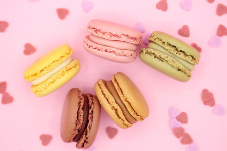 Top view macaroons with little hearts on pink background. Valentines day concept, love, surprise, food delivery, sweet table menuの写真素材