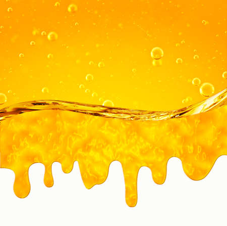 Liquid flows yellow, for the project, oil, honey, beer or other variants on white background, area for textの写真素材