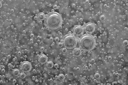 Black-and-white background with big and small grey bubbles inside a gray liquid. の写真素材