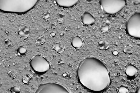 Black-and-white background with big and small grey bubbles inside a gray liquid.の写真素材